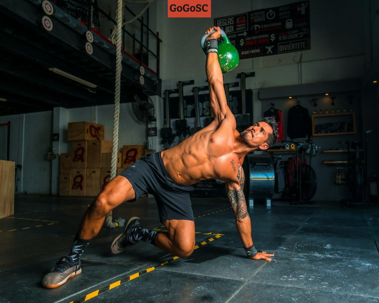 man in black shorts and black tank top doing push up