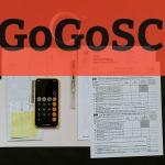 black Android smartphone near ballpoint pen, tax withholding certificate on top of white folder